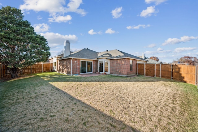 rear view of property featuring a yard and a patio area