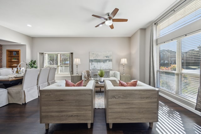 living room featuring ceiling fan, a healthy amount of sunlight, and dark hardwood / wood-style floors