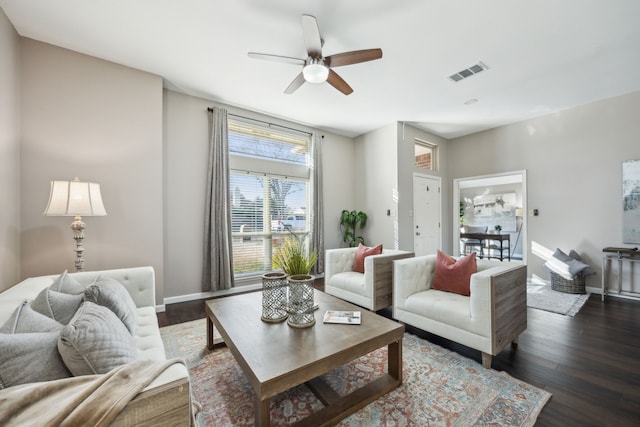 living room featuring ceiling fan and dark wood-type flooring