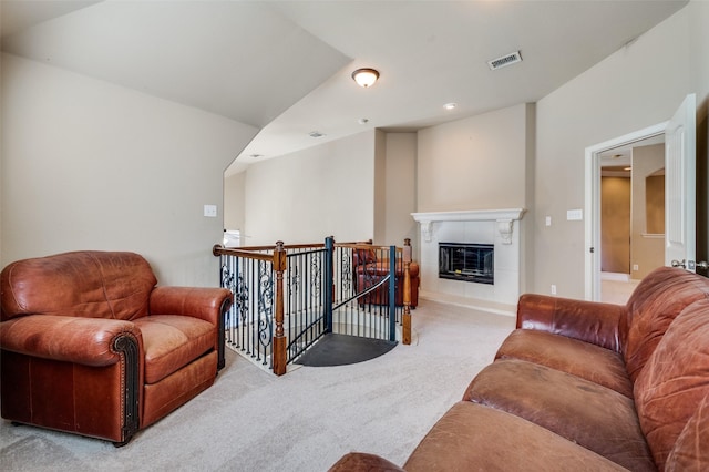 living room featuring light colored carpet and a fireplace