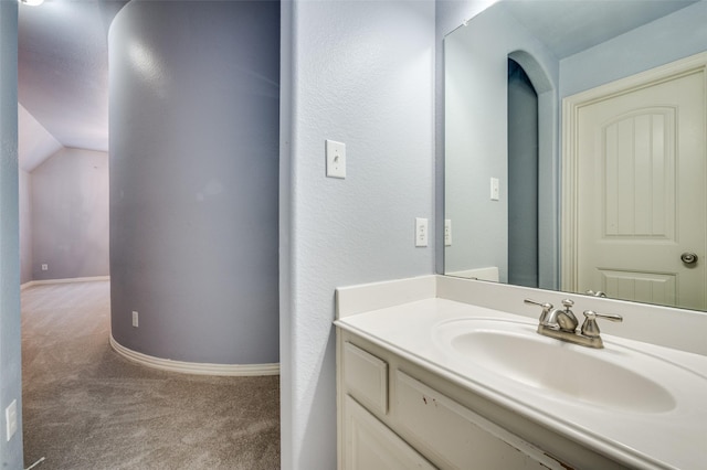 bathroom featuring vanity and lofted ceiling