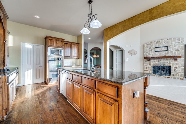 kitchen with a breakfast bar, a kitchen island with sink, sink, dark hardwood / wood-style flooring, and stainless steel appliances