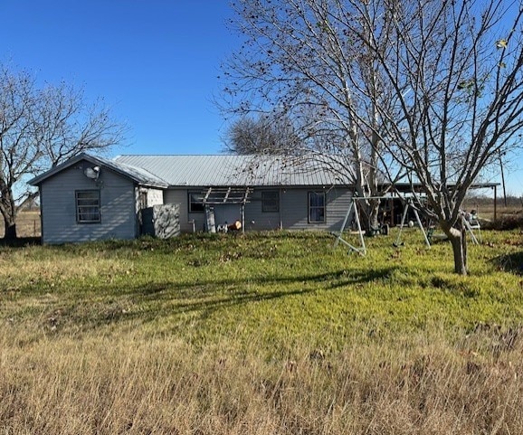 rear view of house featuring a yard