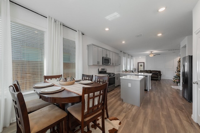 kitchen with hardwood / wood-style floors, ceiling fan, gray cabinets, kitchen peninsula, and stainless steel appliances