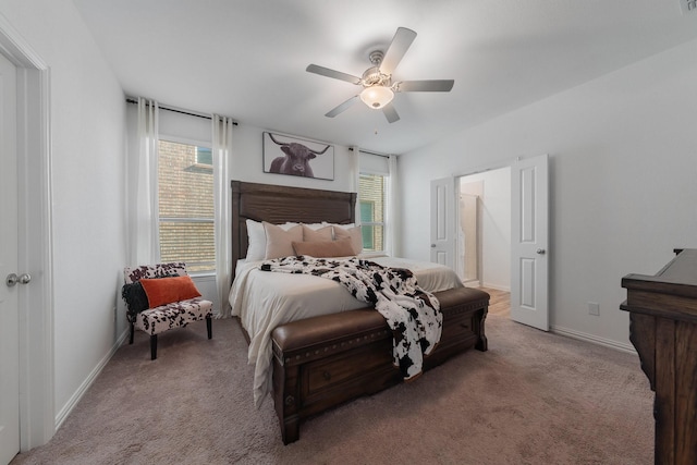 bedroom with multiple windows, ceiling fan, and light carpet