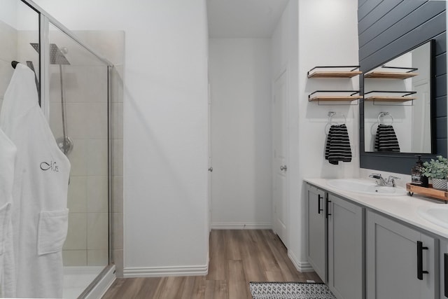 bathroom with vanity, wood-type flooring, and tiled shower