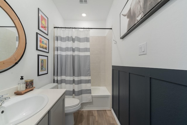 full bathroom featuring vanity, toilet, wood-type flooring, and shower / tub combo