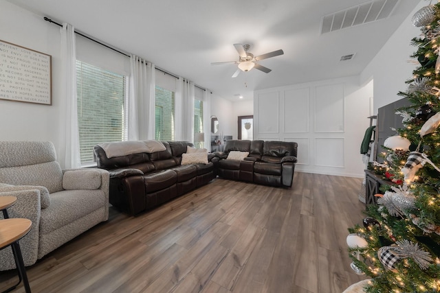 living room featuring ceiling fan and dark wood-type flooring