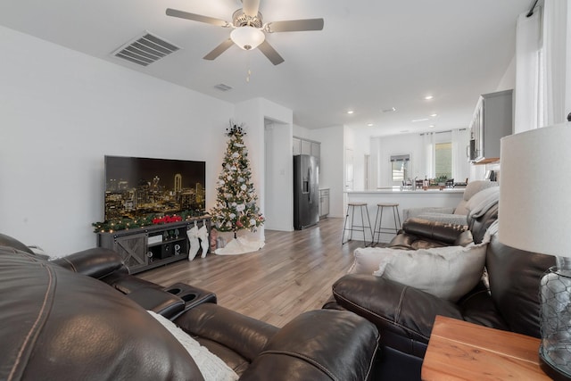 living room with ceiling fan and light hardwood / wood-style floors