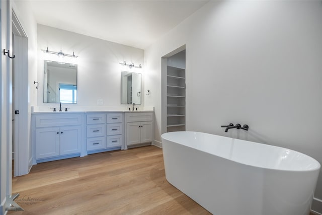 bathroom featuring vanity, a tub to relax in, and hardwood / wood-style flooring