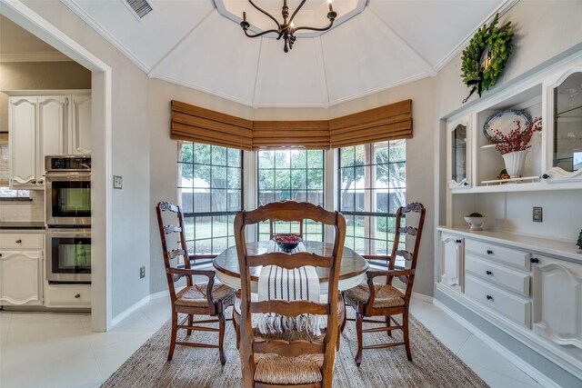 dining area with light tile patterned floors, a healthy amount of sunlight, and vaulted ceiling