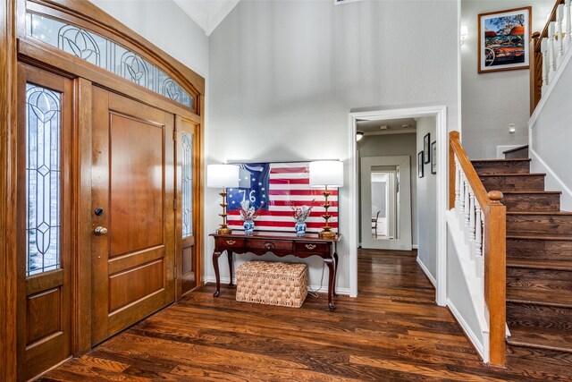 entrance foyer featuring a wealth of natural light, crown molding, and dark hardwood / wood-style floors