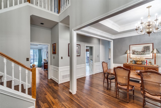 dining room featuring a chandelier, dark wood-type flooring, a high ceiling, and ornamental molding