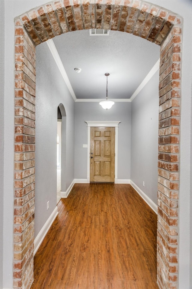 foyer entrance with hardwood / wood-style floors, crown molding, and a textured ceiling