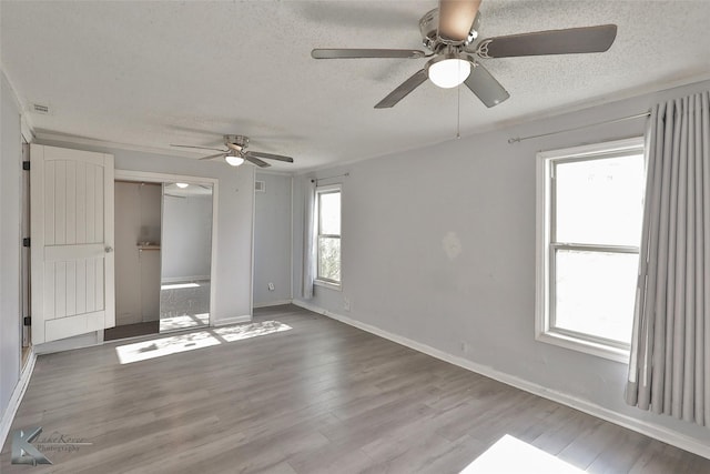 unfurnished bedroom featuring a closet, ceiling fan, hardwood / wood-style floors, and a textured ceiling