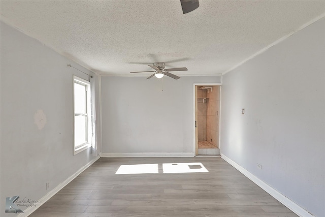 spare room with ceiling fan, wood-type flooring, and a textured ceiling