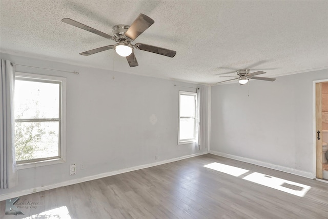 empty room with ceiling fan, a textured ceiling, and light wood-type flooring