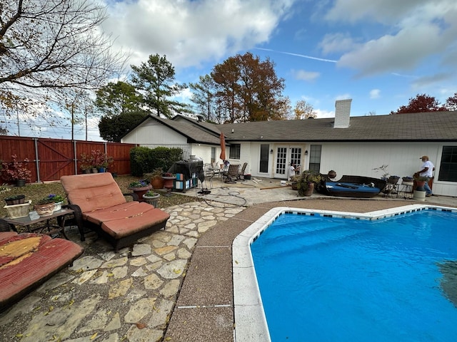 view of pool featuring fence private yard, a fenced in pool, a patio, and french doors