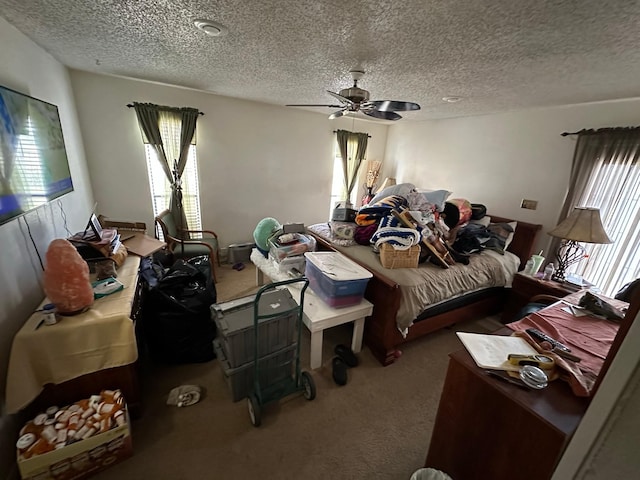 bedroom with a ceiling fan, carpet, and a textured ceiling