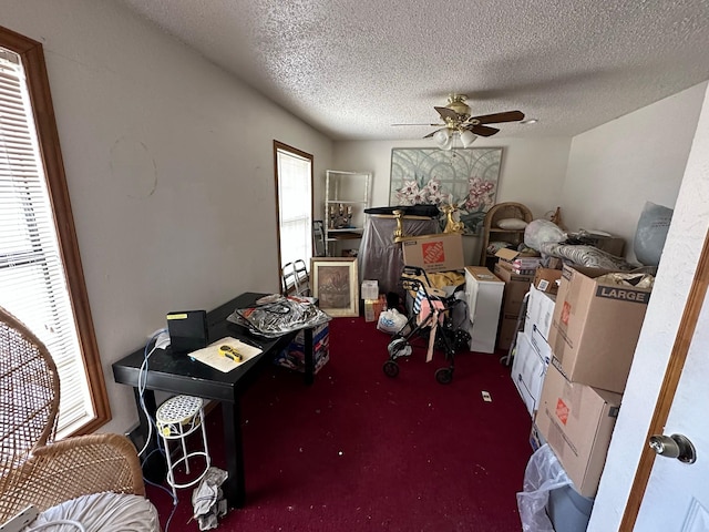 office space featuring dark colored carpet, a textured ceiling, and ceiling fan