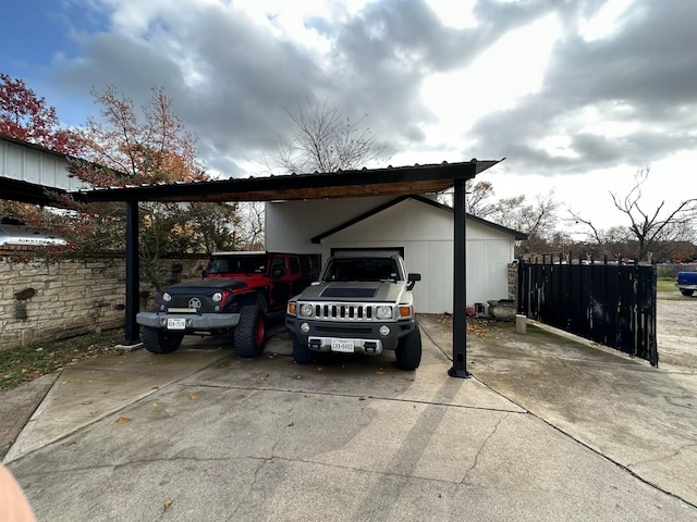 view of parking / parking lot featuring a carport, driveway, and fence