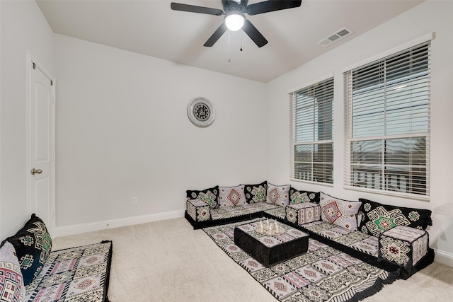 carpeted living room with ceiling fan