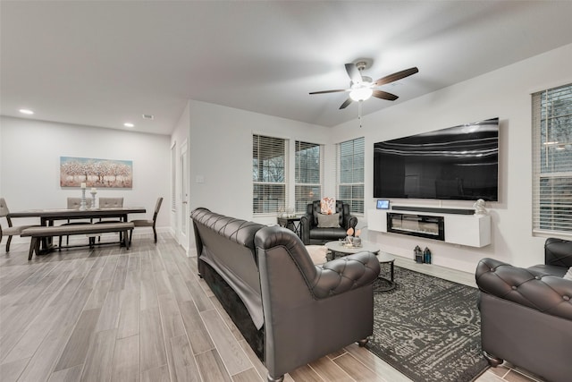 living room featuring ceiling fan and light hardwood / wood-style floors