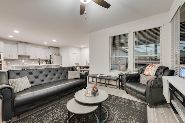 living room featuring ceiling fan and sink