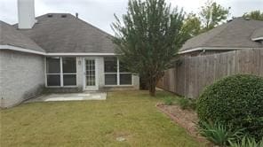 rear view of property featuring a yard