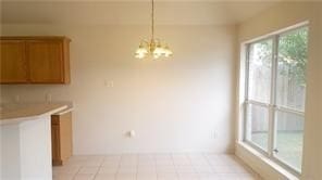 unfurnished dining area with a notable chandelier