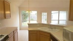 kitchen featuring range, a notable chandelier, a healthy amount of sunlight, and sink