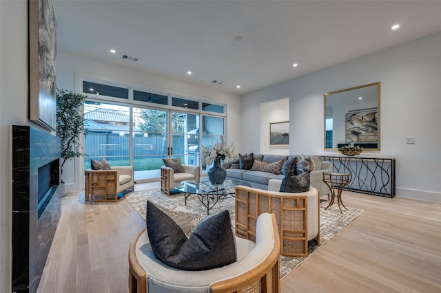 living room with a premium fireplace and light hardwood / wood-style flooring