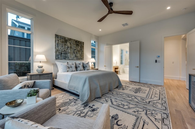 bedroom featuring connected bathroom, ceiling fan, and light hardwood / wood-style flooring