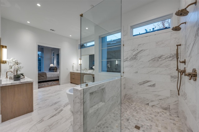 bathroom featuring tiled shower and vanity