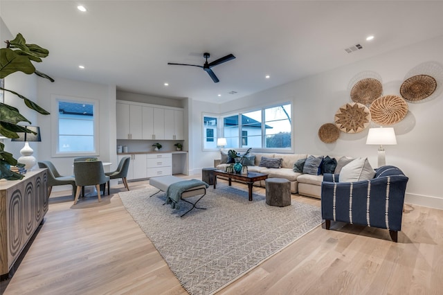 living room featuring ceiling fan and light hardwood / wood-style floors