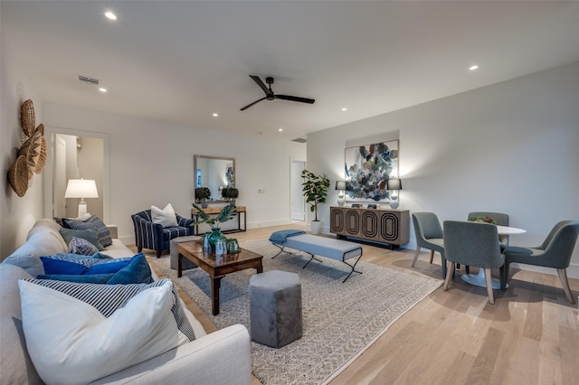 living room with ceiling fan and light hardwood / wood-style flooring