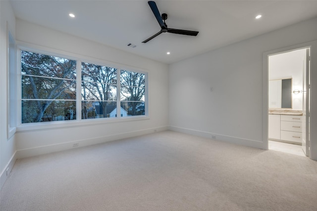 spare room featuring light colored carpet and ceiling fan