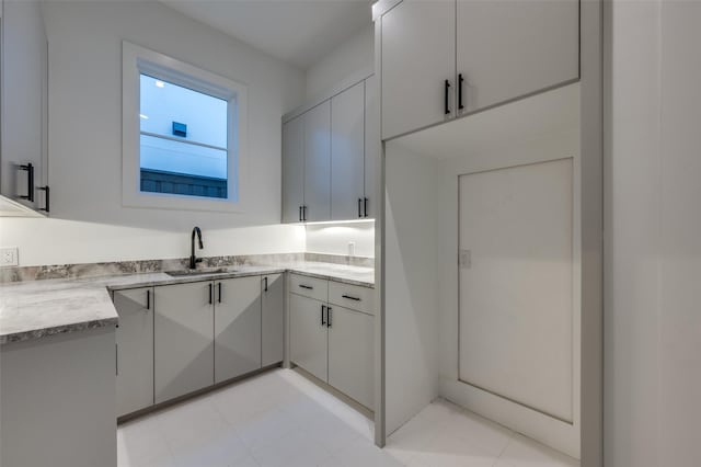 kitchen featuring light stone countertops and sink