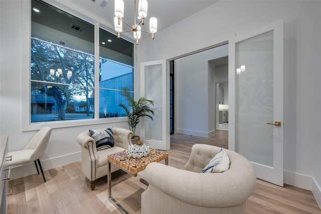 living area with a notable chandelier and light wood-type flooring