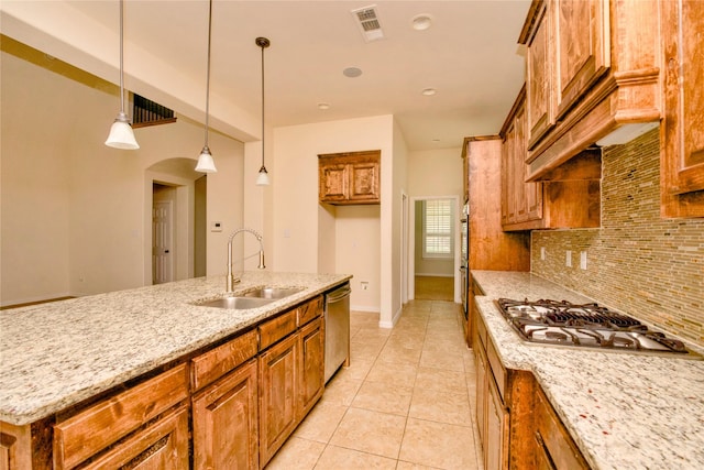 kitchen with backsplash, sink, hanging light fixtures, light stone counters, and stainless steel appliances