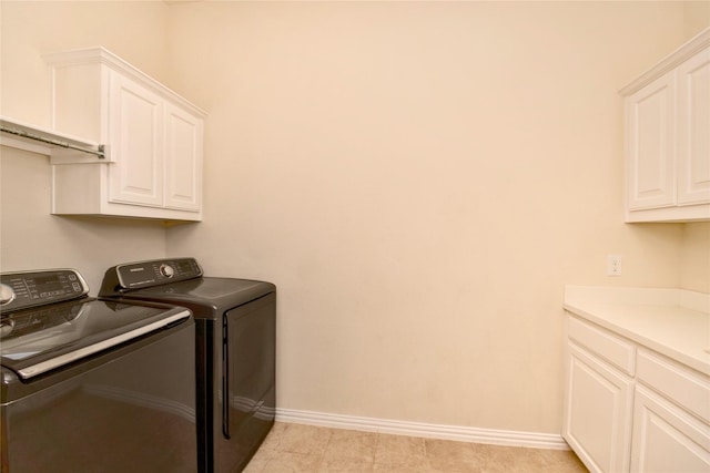 washroom with washer and dryer, cabinets, and light tile patterned flooring