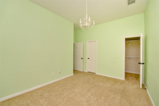 unfurnished bedroom featuring light carpet and an inviting chandelier