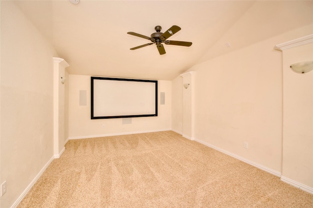 carpeted home theater room with ceiling fan and vaulted ceiling