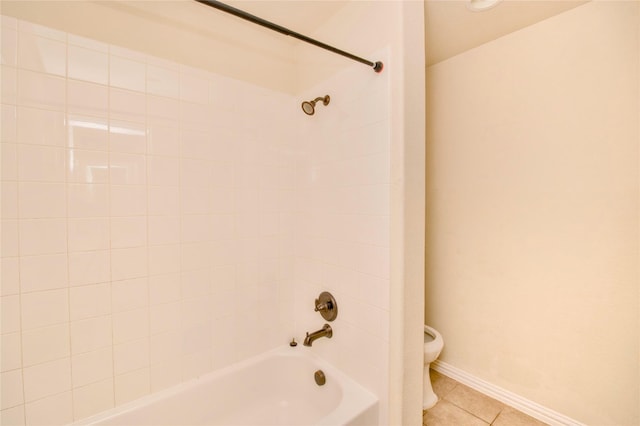 bathroom with tile patterned floors, toilet, and tiled shower / bath