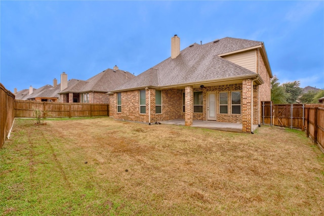 back of house featuring a lawn and a patio area