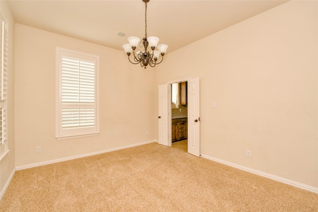 unfurnished room featuring light carpet and a chandelier