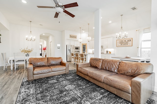 living room featuring dark hardwood / wood-style floors and ceiling fan with notable chandelier