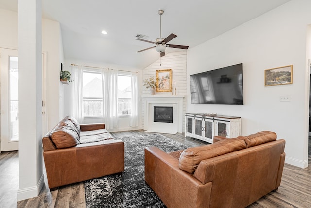 living room with ceiling fan, lofted ceiling, and light wood-type flooring