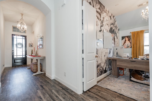 foyer with a notable chandelier, dark wood-type flooring, and a wealth of natural light