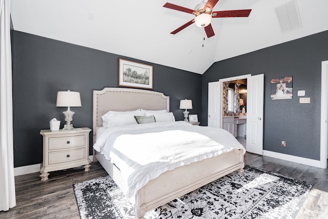 bedroom with dark hardwood / wood-style flooring, ensuite bathroom, ceiling fan, and lofted ceiling